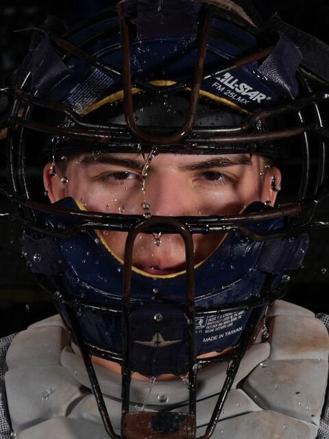 Close-up of a baseball catcher in his mask with water drops on his face