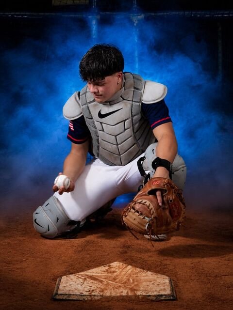Catcher kneeling by home plate with the ball and glove