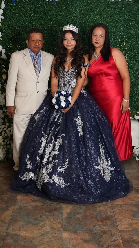 The quinceañera with two companions, one in a light suit