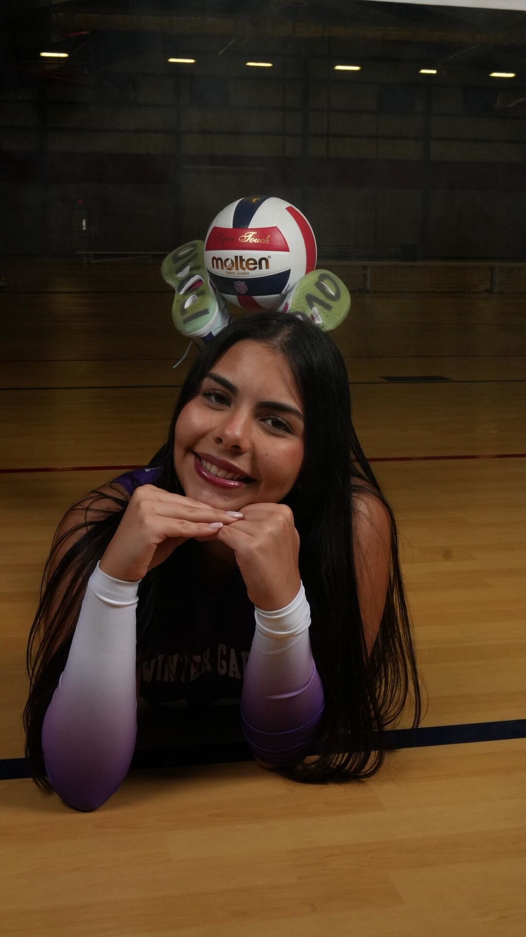 Player lying on the court with the ball on her head